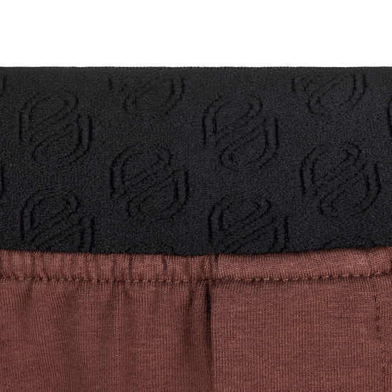Détail de la taille élastiquée du pantalon de pyjama marron SLAZZ pour homme, avec logo discret en relief ton sur ton.